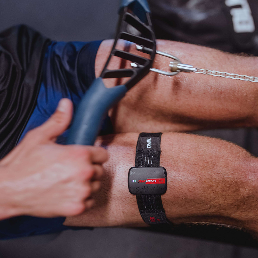 Athlete using Train.Red FYER 2.0 PRO wearable muscle oxygen sensor on thigh during strength training