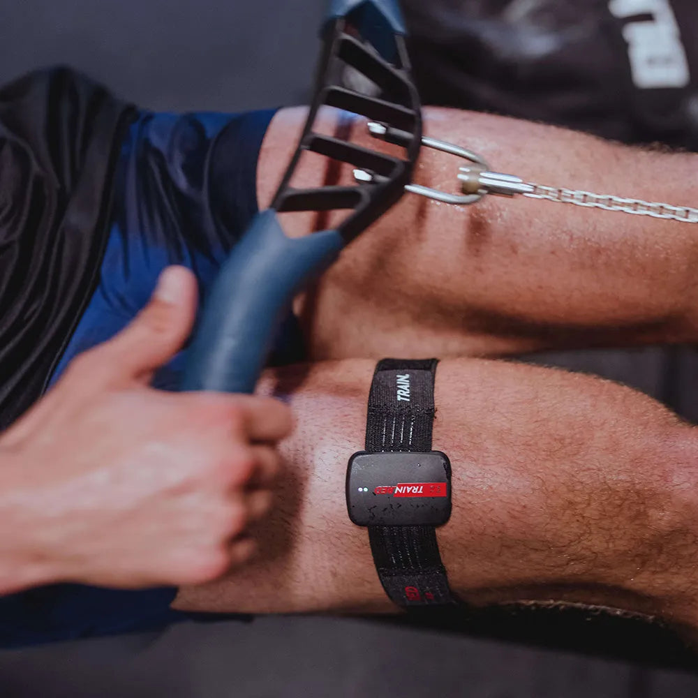 Athlete using Train.Red FYER 2.0 PRO wearable muscle oxygen sensor on thigh during strength training